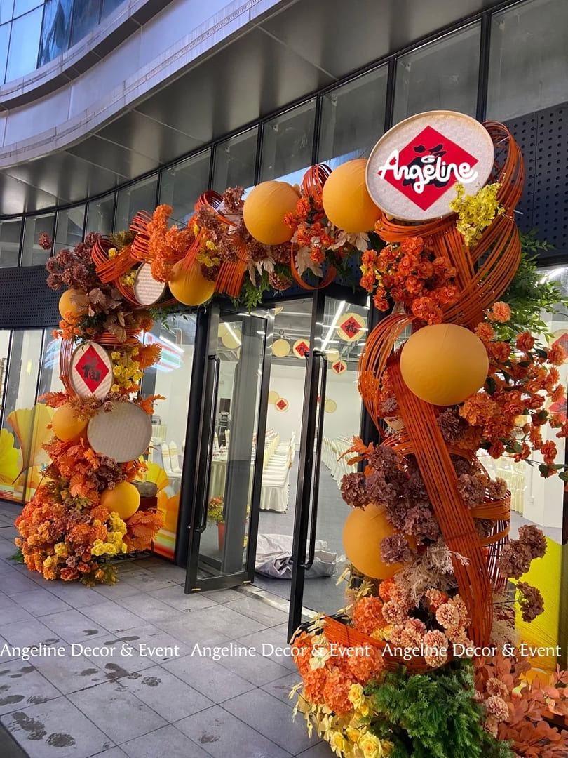 Concept Trang Trí Tết 2026 “Tân Niên Khai Lộc – Vạn Sự Cát Tường”: Cổng Check-in Đỏ Cam Rực Rỡ, Ấm Áp & Sang Trọng Cho Sảnh Doanh Nghiệp Angeline